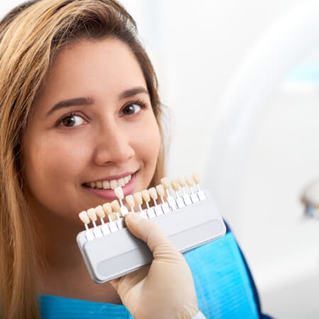 Woman's smile compared with veneers color options