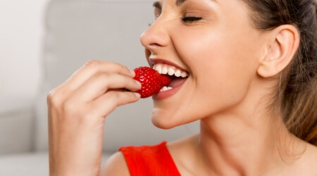 Woman eating a strawberry