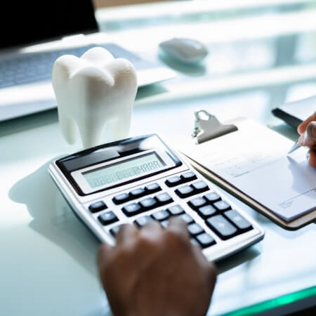 Person using calculator to determine the cost of treatment