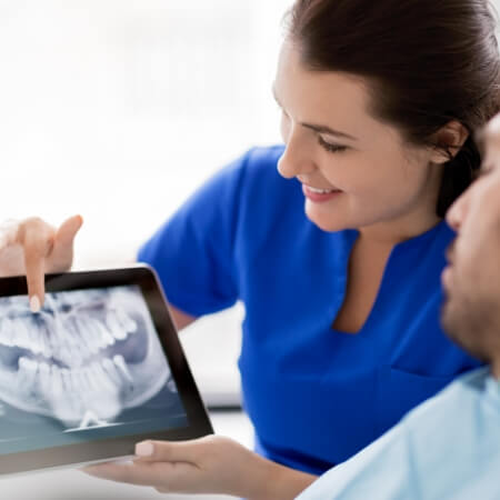 Dental team members looking at digital x rays