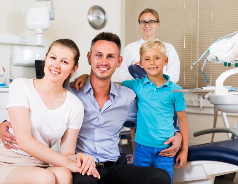 Parents and child smiling during family dentistry visit