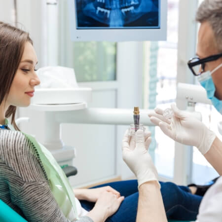 Dentist explaining the four step dental implant process