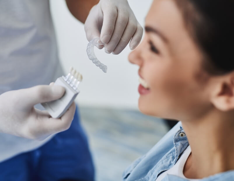 Dentist showing dental patient an Invisalign clear aligner tray