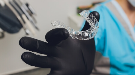 Dentist holding a clear aligner tray