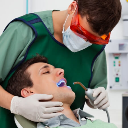 Dentist placing dental sealants
