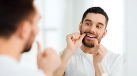 Man performing at home oral hygiene routine