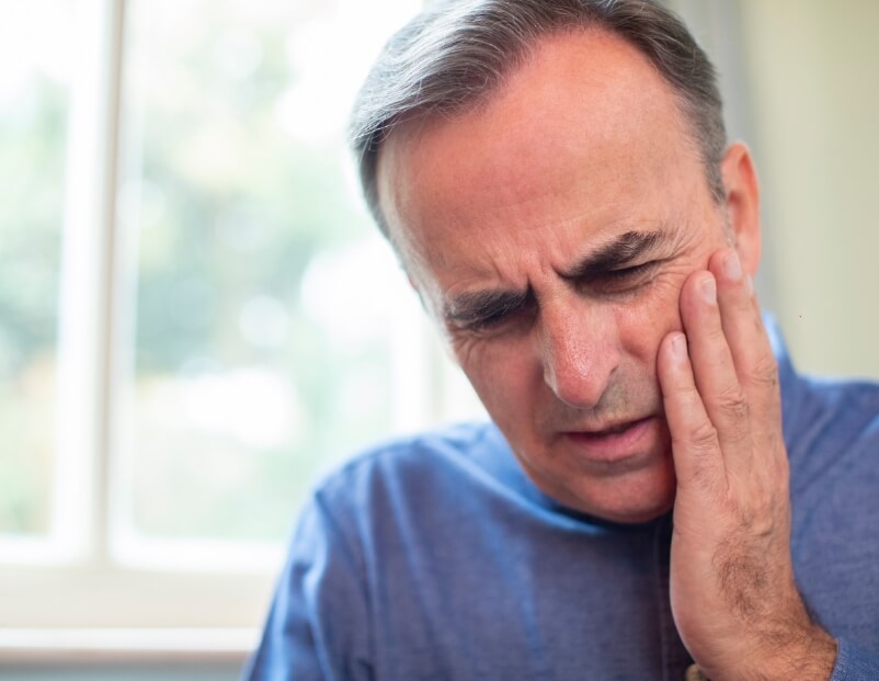 Man holding his jaw in pain