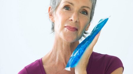 Person holding ice pack to cheek