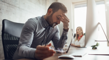 Man experiencing stress holding head